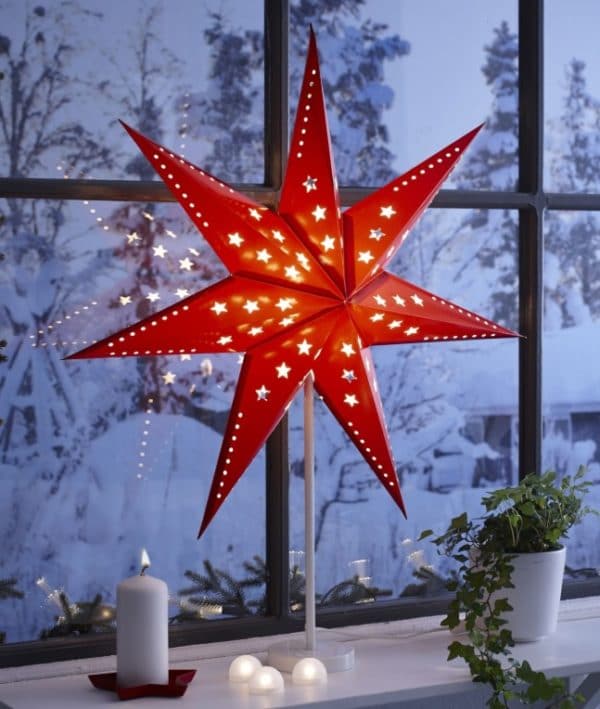 Rozsvícená červená vánoční hvězda za oknem