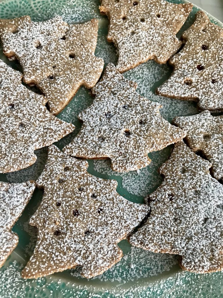 Čokoládové vánoční cukroví ve tvaru stromečku, zdobené posypkou z cukru a skořice.