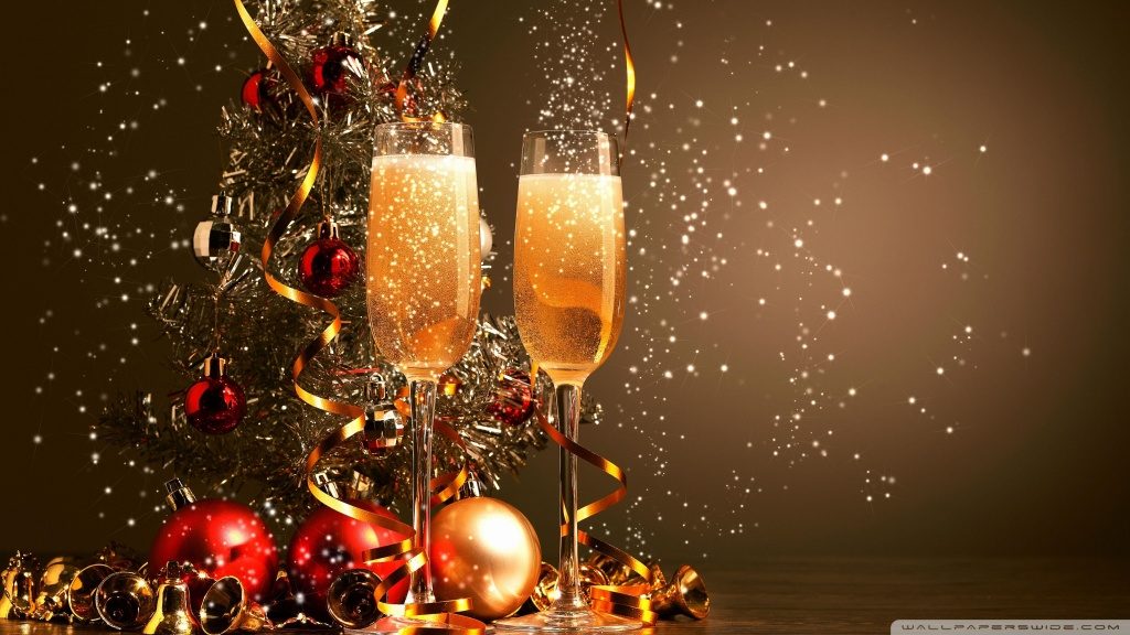 Novoroční pozadí s výzdobou z baněk a dvěma sklenicemi plnými šampaňského.