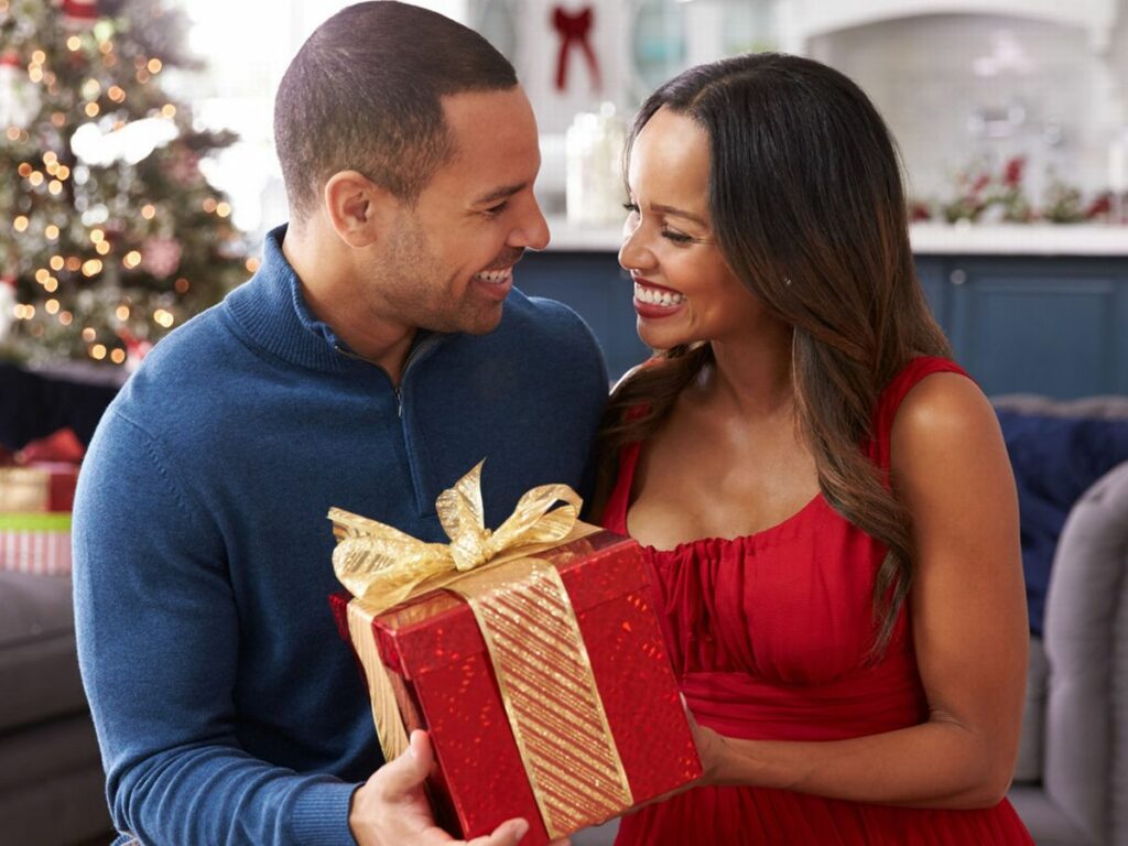 Muž se ženou držící svůj společný vánoční dárek.