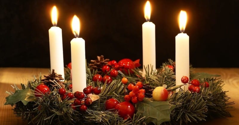adventní vánoční věnec s bílými svíčkami, jehličím a ozdobami