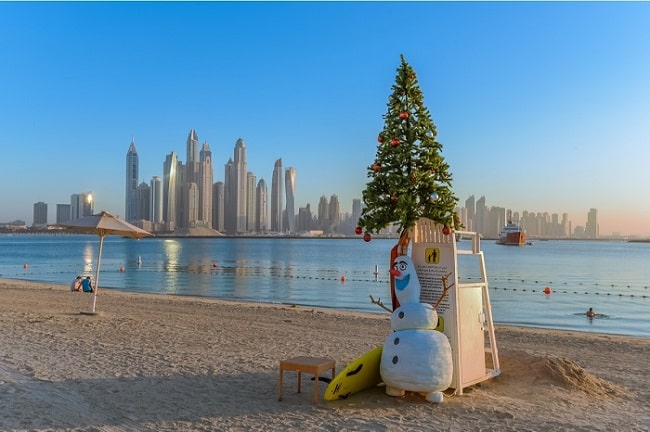 Vánoční strom a sněhulák u moře v Dubaji