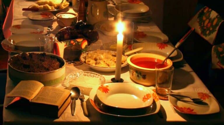 Prostřený stůl ke štědrovečerní večeři s tradičními jídly, které se jí o polských vánocích a otevřenou biblí