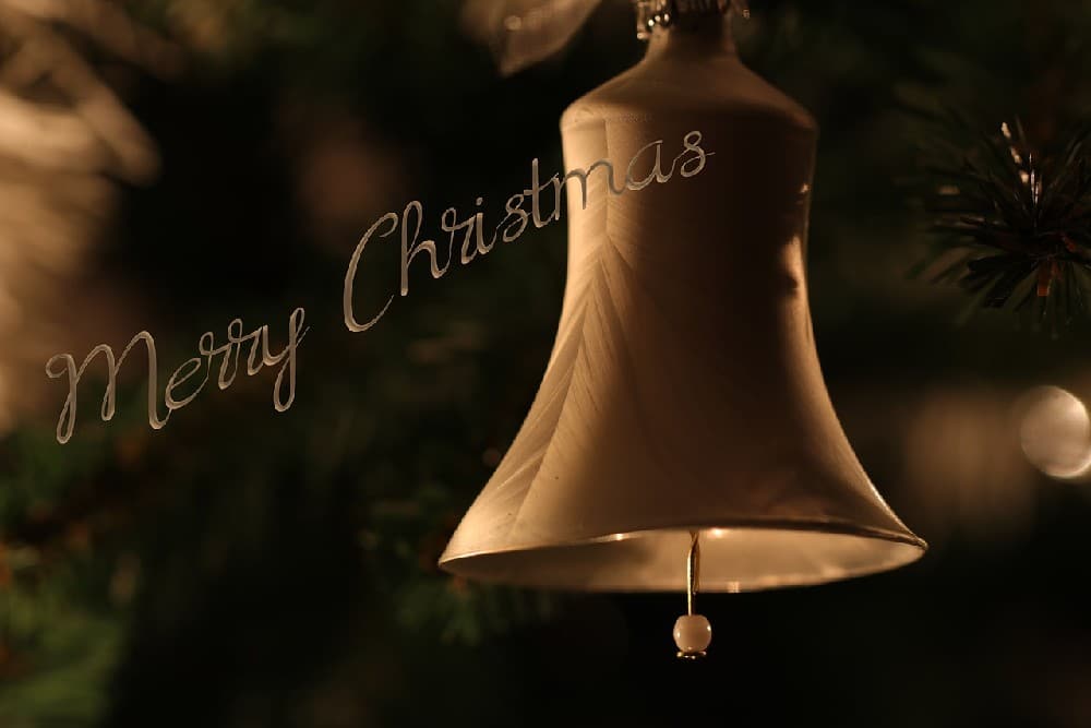 Vánoční pohlednice ke stažení zdarma se zlatým zvonečkem a nápisem Merry Christmas