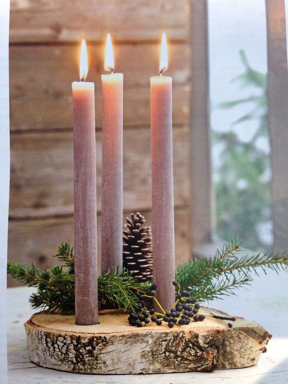 Vánoční svícen na hřbitov vyrobený z kulatého dřeva, chvojí, šišek a tří svíček