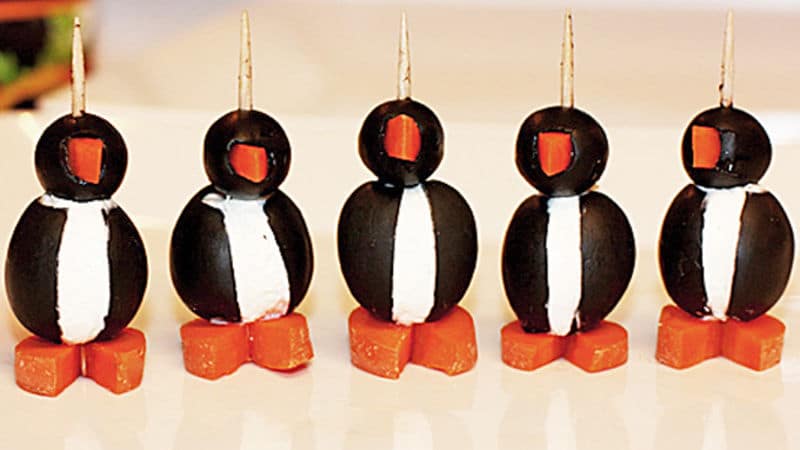 Pět jednohubek z černých oliv nazdobených tak, aby vypadaly jako stojící tučňáci