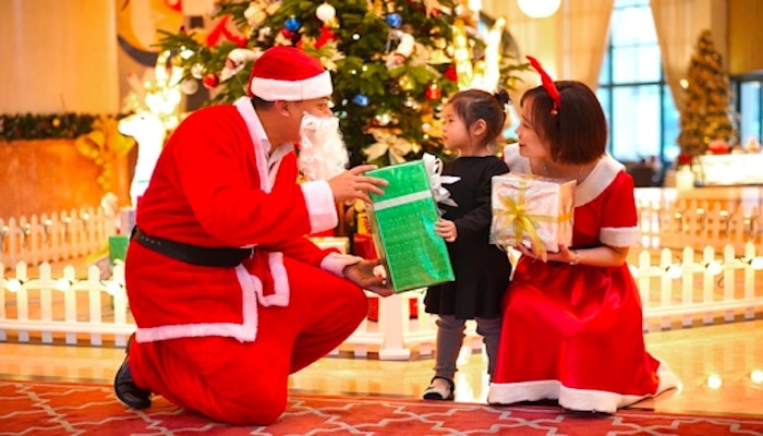 Vietnamský Santa Claus předává malému dítěti dáreček.