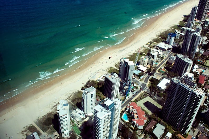 Austrálii, nádherné písečné pláže, lemované průzračným mořem, se táhnou podél velkoměst s vysokými domy.
