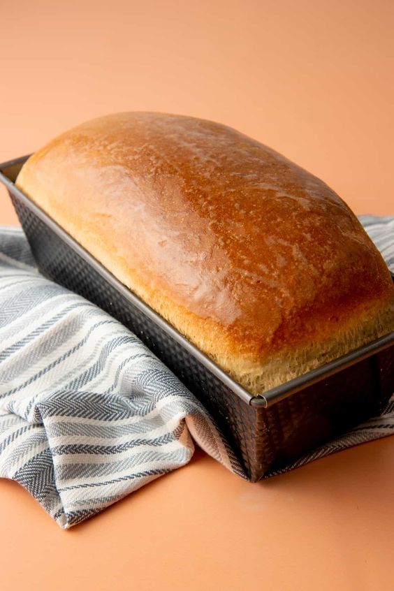 Upečený chlebík se zlatou kůrkou v chlebové formě.