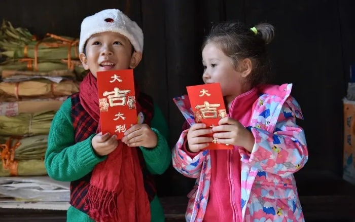 Čínské děti s novoročními červenými obálkami.