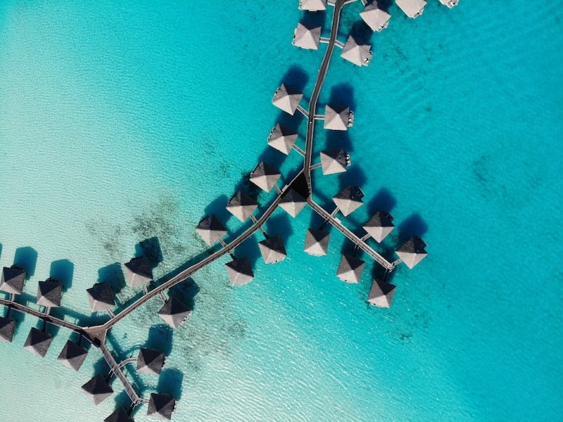 Plovoucí chatrče na průzračném moři na ostrově Bora Bora.