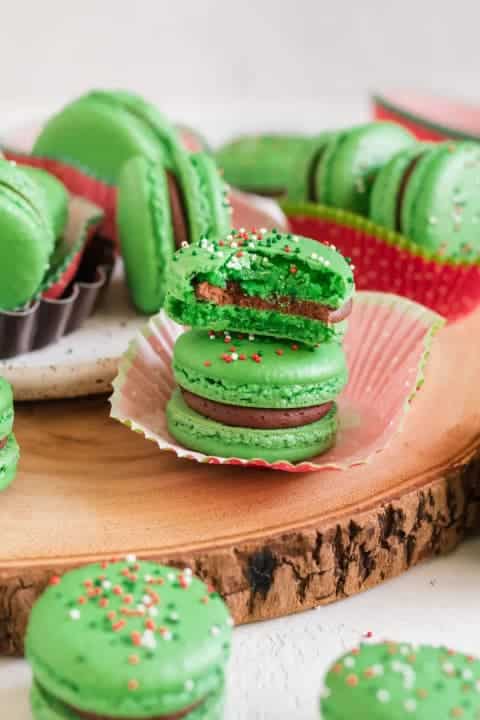 Zelené makronky s vánočními posypkami plněné krémovou a bohatou náplní z hořké čokolády. 