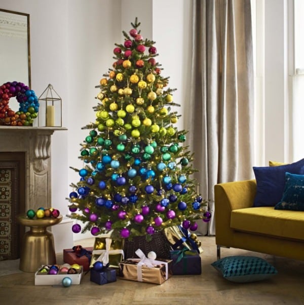 Vánoční strom ozdobený ozdobami v barvách duhy.