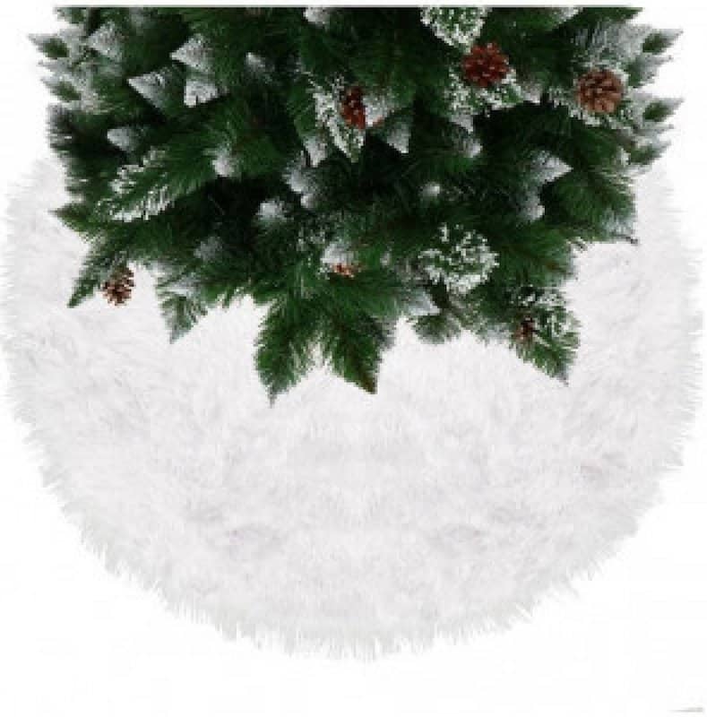 Bíle laděný vánoční stromek na kožešinovém koberečku.
