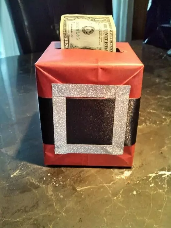 Krabice od kapesníků, ze které vyčuhují darované bankovky.