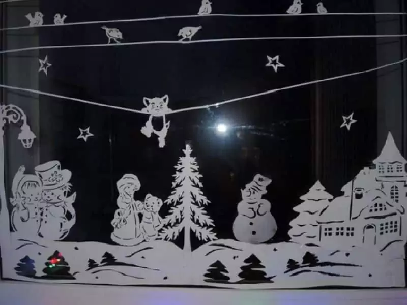 Hotové vánoční vystřihovánky z papíru na okně - město, sněhulák, lidé a kočka visící na drátech