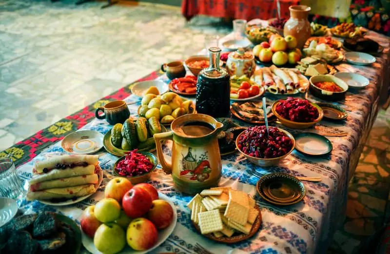 Slavnostně prostřený stůl s mnoha druhy jídel na slavnostní večeři na ukrajinské Vánoce.